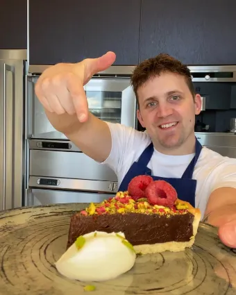 Chef Jon Watts holding a chocolate dessert